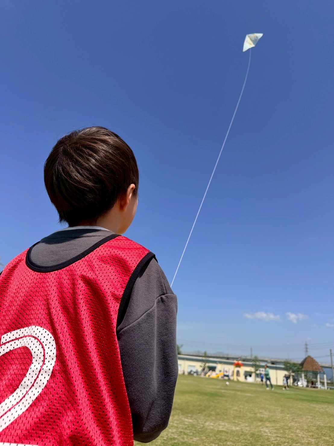 青空の下で凧あげを楽しむお子様